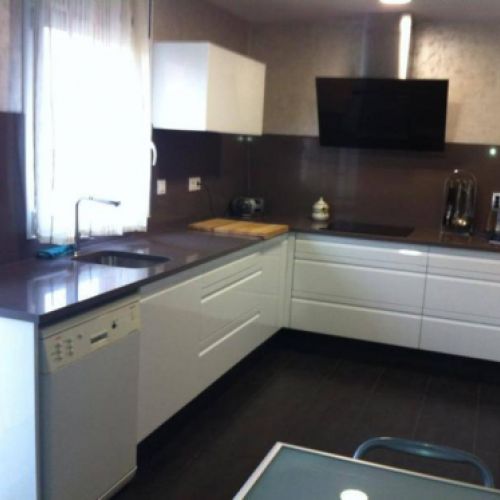 Reforma de cocina con muebles lisos en blanco y encimera y frontal en negro