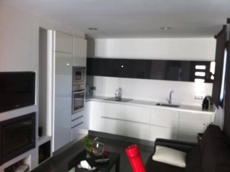 Reforma de cuina integrada al saló amb mobles en color blanc