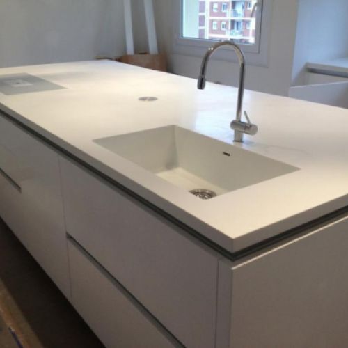 Detall de cuina reformada amb taulell de cuina en to clar