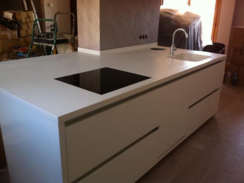 Detall de cuina amb moble blanc i taulell gris clar