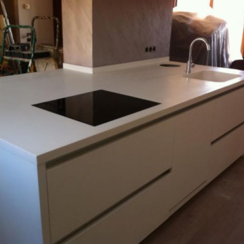 Detall de cuina amb moble blanc i taulell gris clar