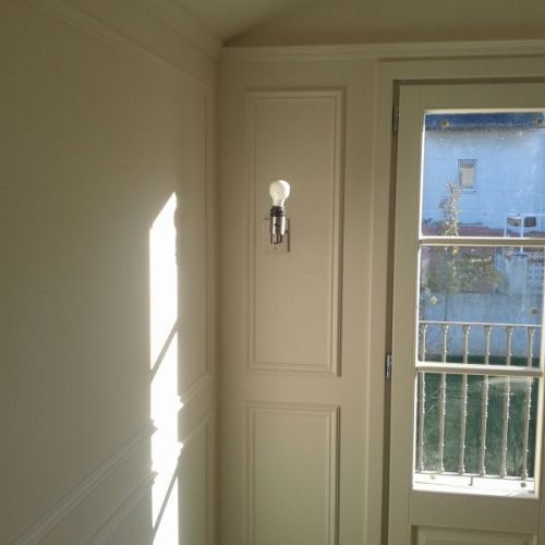 Baño con paredes blancas y molduras de escayola